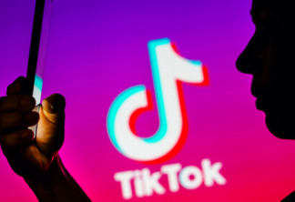 April 6, 2023, Brazil. In this photo illustration, a woman’s silhouette holds a smartphone with the TikTok logo in the background