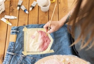 mulher customizando calça jeans